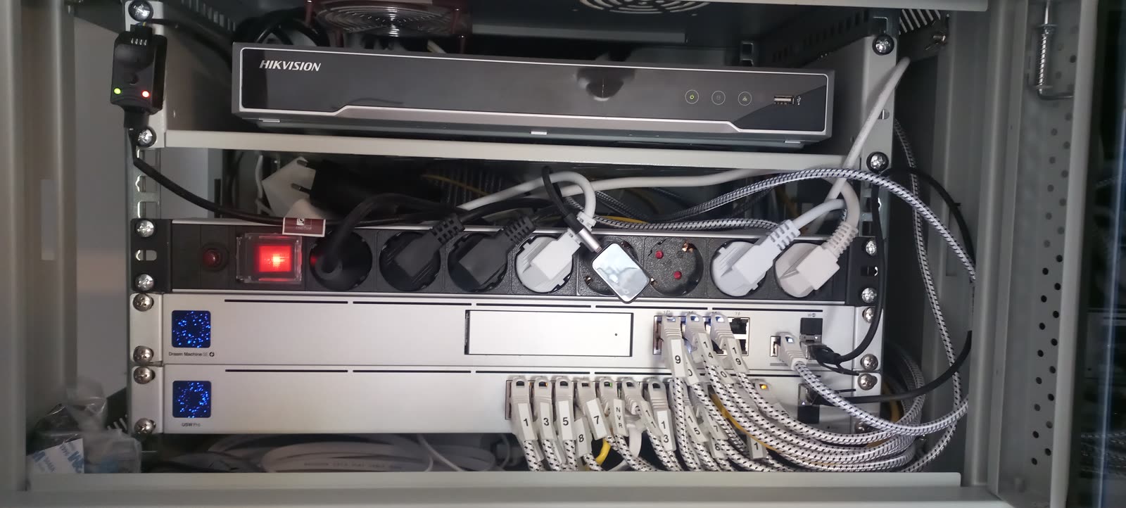 Netzwerkschrank mit UniFi Dream Machine, Switch und Hikvision NVR — strukturiert verkabelt von Friends Electric & SIDOK
